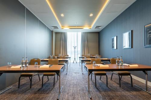 a row of tables and chairs in a room at Crowne Plaza Aberdeen Airport by IHG in Dyce