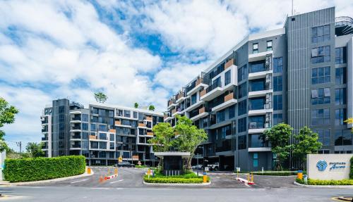 an apartment building with a tree in front of it at Skypark Aurora in Laguna by Banyan Living in Thalang