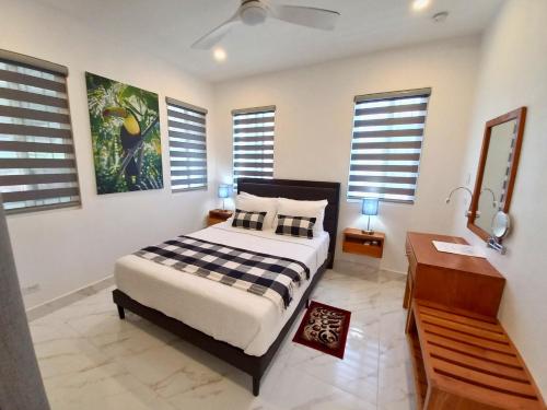a bedroom with a bed and a desk and windows at Javiellie Luxury Villa in San Ignacio