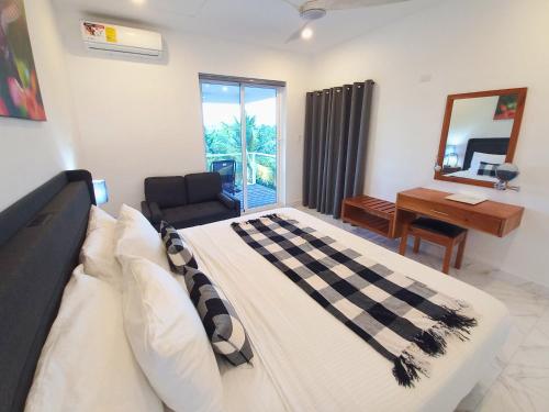 a bedroom with a bed and a desk and a mirror at Javiellie Luxury Villa in San Ignacio