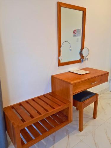 a bathroom with a wooden desk and a mirror at Javiellie Luxury Villa in San Ignacio