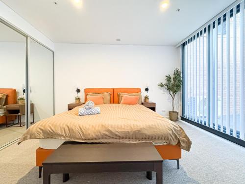 a bedroom with a large bed and large windows at Luxurious Apartment In heart of Bankstown CBD in Bankstown
