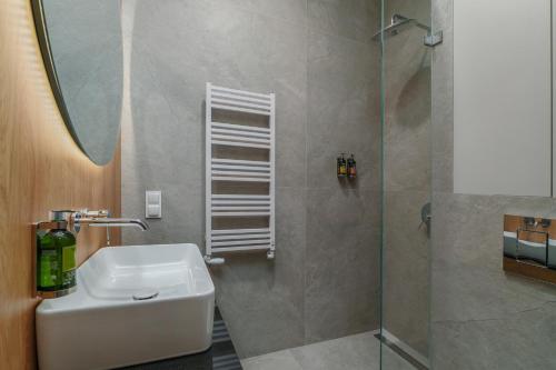 une salle de bain avec un lavabo et une douche dans l'établissement Aparthotel Nad Zatoką- Apartament Elliot- Plaża Miejska, à Olsztyn