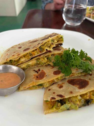 a white plate with three tortilla sandwiches with sauce at A 50 Arugambay in Arugam Bay