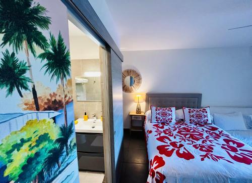 a bedroom with a bed and a bathroom with a sink at Tehautahi Cozy Lodge 1 in Papeete