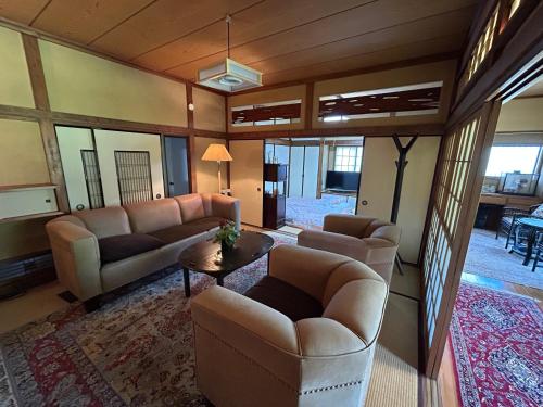 a living room with couches and a table at Chiba Homestay by Lek บ้านพักใกล้นาริตะโตเกียว in Yotsukaidō