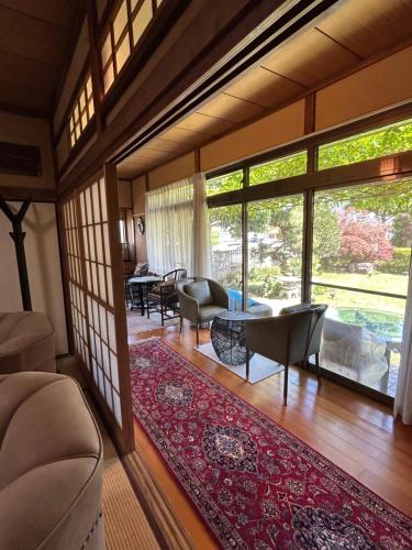 a living room filled with furniture and a large window at Chiba Homestay by Lek บ้านพักใกล้นาริตะโตเกียว in Yotsukaidō