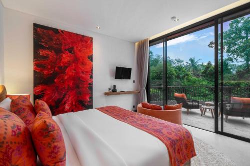 a bedroom with a bed and a large window at Villa Gayatri Sindu by BaliSuperHost in Ubud