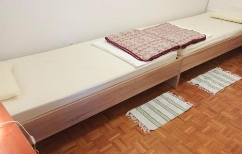 a bed in a room with two rugs on the floor at Holiday Home Baric Draga Baric Draga in Barić Draga