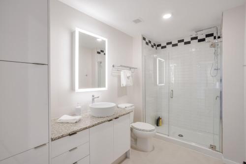 a white bathroom with a toilet and a shower at CozySuites Sky Central #20 in Cincinnati
