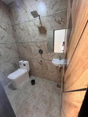 a bathroom with a toilet and a sink at C&f property in Bhuj