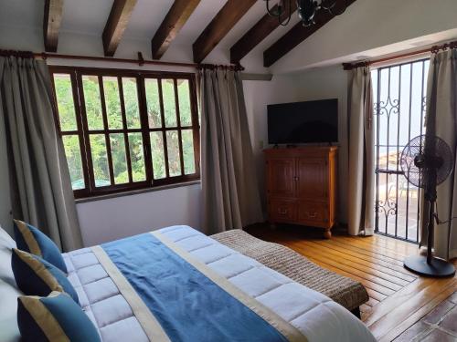 a bedroom with a bed and a flat screen tv at Casa de las Conchas Cuernavaca in Cuernavaca