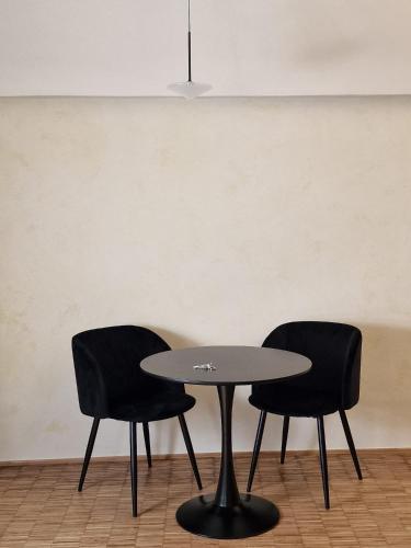 two chairs and a table in front of a wall at 1LoftMatera in Matera