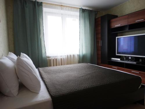 a bedroom with a bed with a television and a window at InnDays on Sportivnaya in Moscow