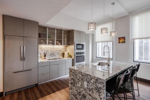 a kitchen with a large island with a counter top at CozySuites Sky Central #21 in Cincinnati