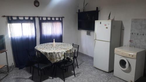 a kitchen with a table and a white refrigerator at Daiana Carlos temporarios in Estación Guadalupe