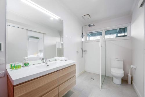 a white bathroom with a sink and a toilet at Yarra Valley 2BR Lux Vineyard Retreat in Dixons Creek