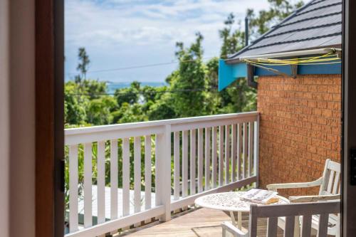 a balcony with a table and chairs on a porch at Spooky Beach Lodge - Oceanstays in Yamba