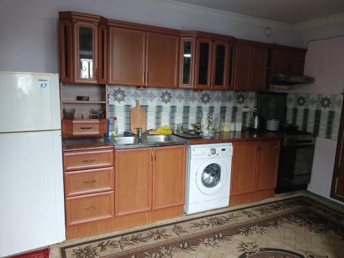 a kitchen with wooden cabinets and a washing machine at Norik's Guest House in Sevan