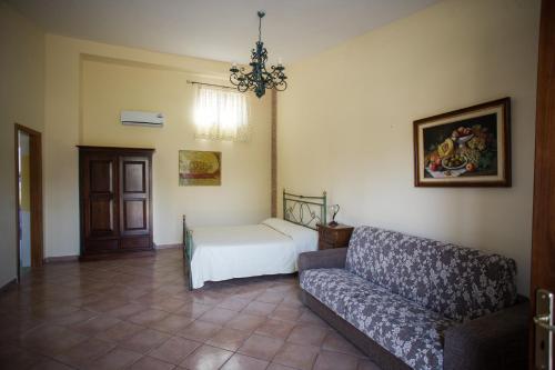 ポンペイにあるアジエンダ アグリツーリスティカ ヴィヴィ ナトゥーラのソファとベッドのあるリビングルーム
