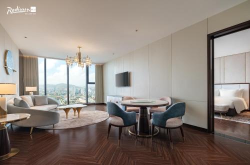 a hotel room with a bed and a living room at Radisson Blu Ha Long Bay in Ha Long