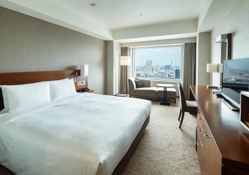 a hotel room with a large bed and a television at Odakyu Hotel Century Southern Tower in Tokyo