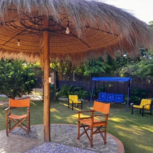 a table and chairs under a straw umbrella at Kitty Roga in Atyrá