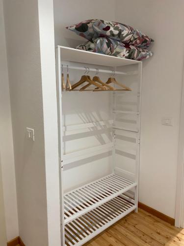a white closet with white shelves and a bed at Affittacamere Torrione in Venzone