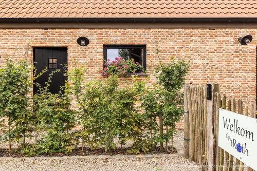 a brick building with a window with flowers in it at Op 't Roth 12 ruime sfeervolle vakantiewoning in 't groen in Oudenaarde