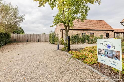 a sign in a yard next to a house at Op 't Roth 12 ruime sfeervolle vakantiewoning in 't groen in Oudenaarde