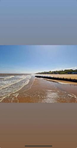 a view of a beach with a pier and the ocean at Modern 3 bedroom caravan near the beach in Walton-on-the-Naze