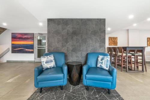 two blue chairs and a table in a living room at Best Western Prince George Downtown in Prince George