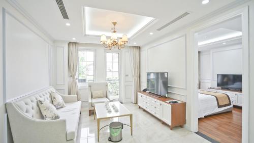 a living room with a bed and a couch and a tv at Nguyen Du Paradise Hotel - Hoan Kiem Lake in Hanoi