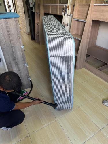 a man is working on a metal radiator on the floor at Panda Lodge Home Stay in Bangkok