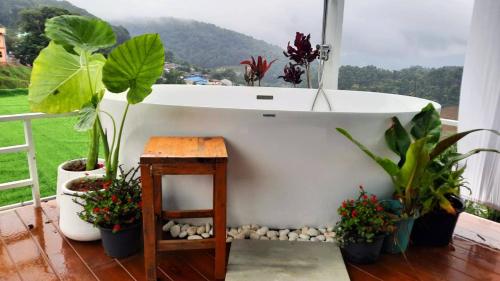 a bath tub sitting next to a window with plants at Maemai Homestay at Monjam in Mon Jam