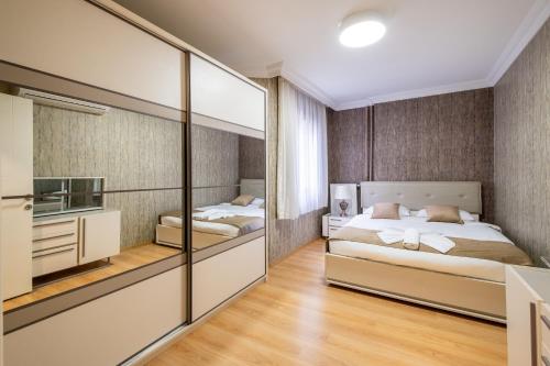 ein Schlafzimmer mit zwei Betten und einem Spiegel in der Unterkunft The Canka Residence And Family Apartment Istanbul City Center - ŞIŞLI in Istanbul