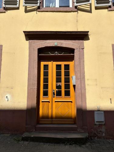 a yellow door on the side of a building at Hypercentre T2 50 m2, Château des Rohan in Saverne