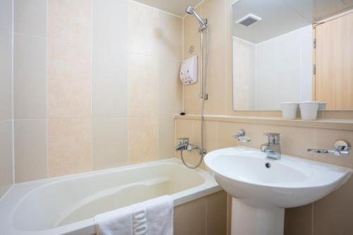a bathroom with a sink and a tub and a mirror at Toyoko Inn Daejeon Government Complex in Daejeon