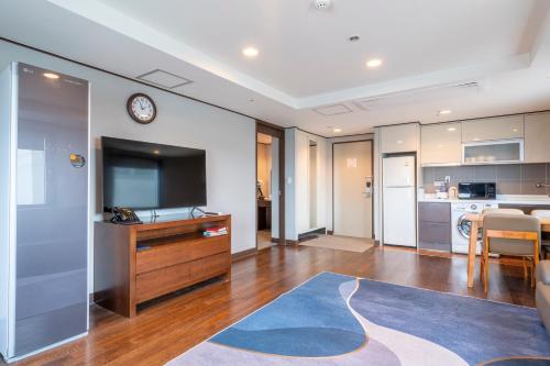 a living room with a television and a kitchen at Toyoko Inn Daejeon Government Complex in Daejeon