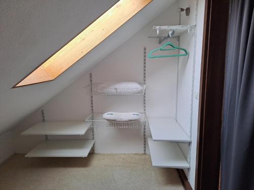a attic room with white shelves and a skylight at Ferienwohnung am Donauradweg in Bad Abbach