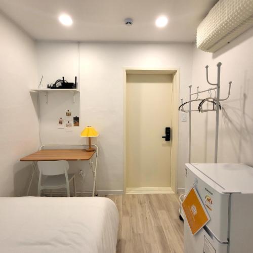 a room with a bed and a table and a door at Humming stay in Seoul