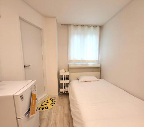 a small room with two beds and a window at Humming stay in Seoul