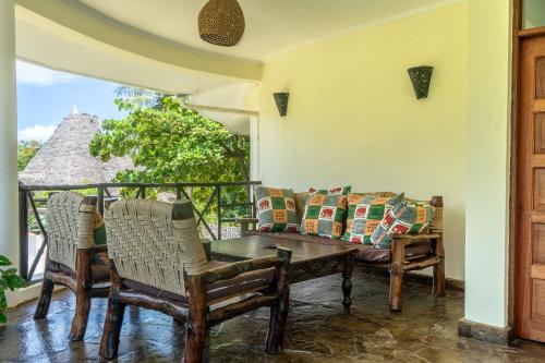 a living room with a couch and a table and chairs at Black Pearl - Luxury Villa with private pool - near beach in Diani Beach