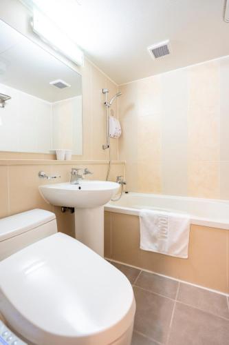 a bathroom with a toilet and a sink and a tub at Toyoko Inn Daejeon Government Complex in Daejeon