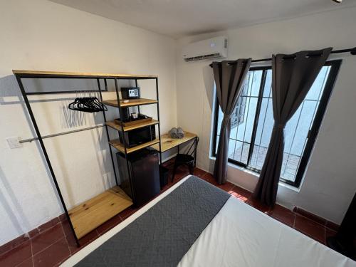 a bedroom with a bed and a desk and windows at The Boat House Suites in Cancún