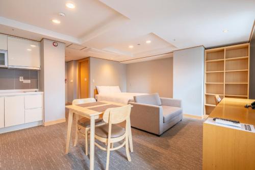 a kitchen and a living room with a table and a couch at Toyoko Inn Daejeon Government Complex in Daejeon