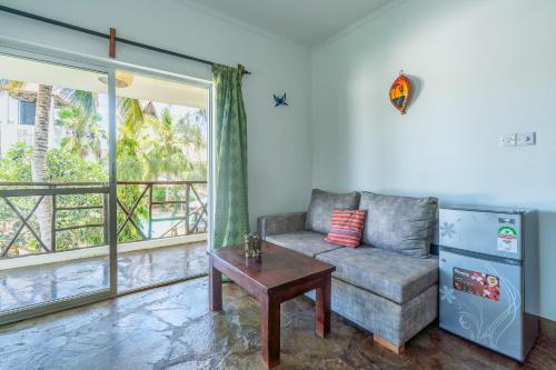 a living room with a couch and a table and a window at Black Pearl - Luxury Villa with private pool - near beach in Diani Beach