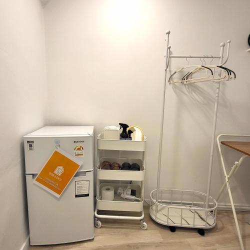 a small refrigerator in a room with a cat sitting on a shelf at Humming stay in Seoul