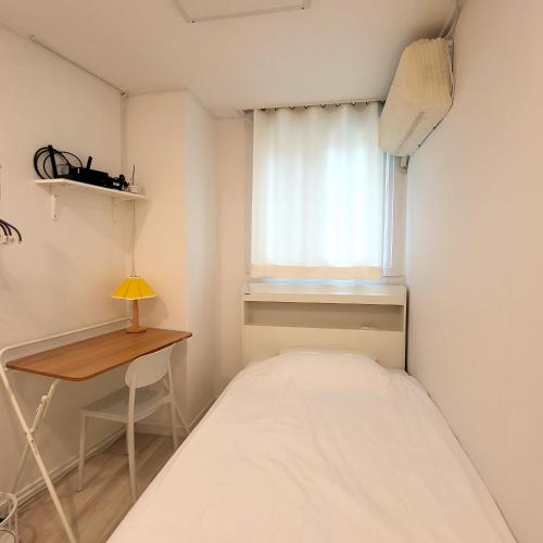 a small bedroom with a bed and a desk at Humming stay in Seoul