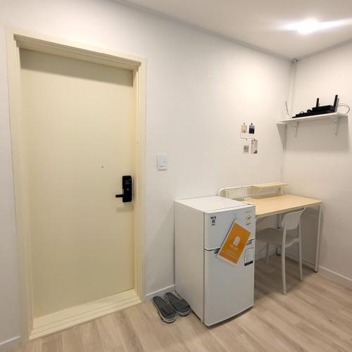 a room with a refrigerator next to a desk at Humming stay in Seoul